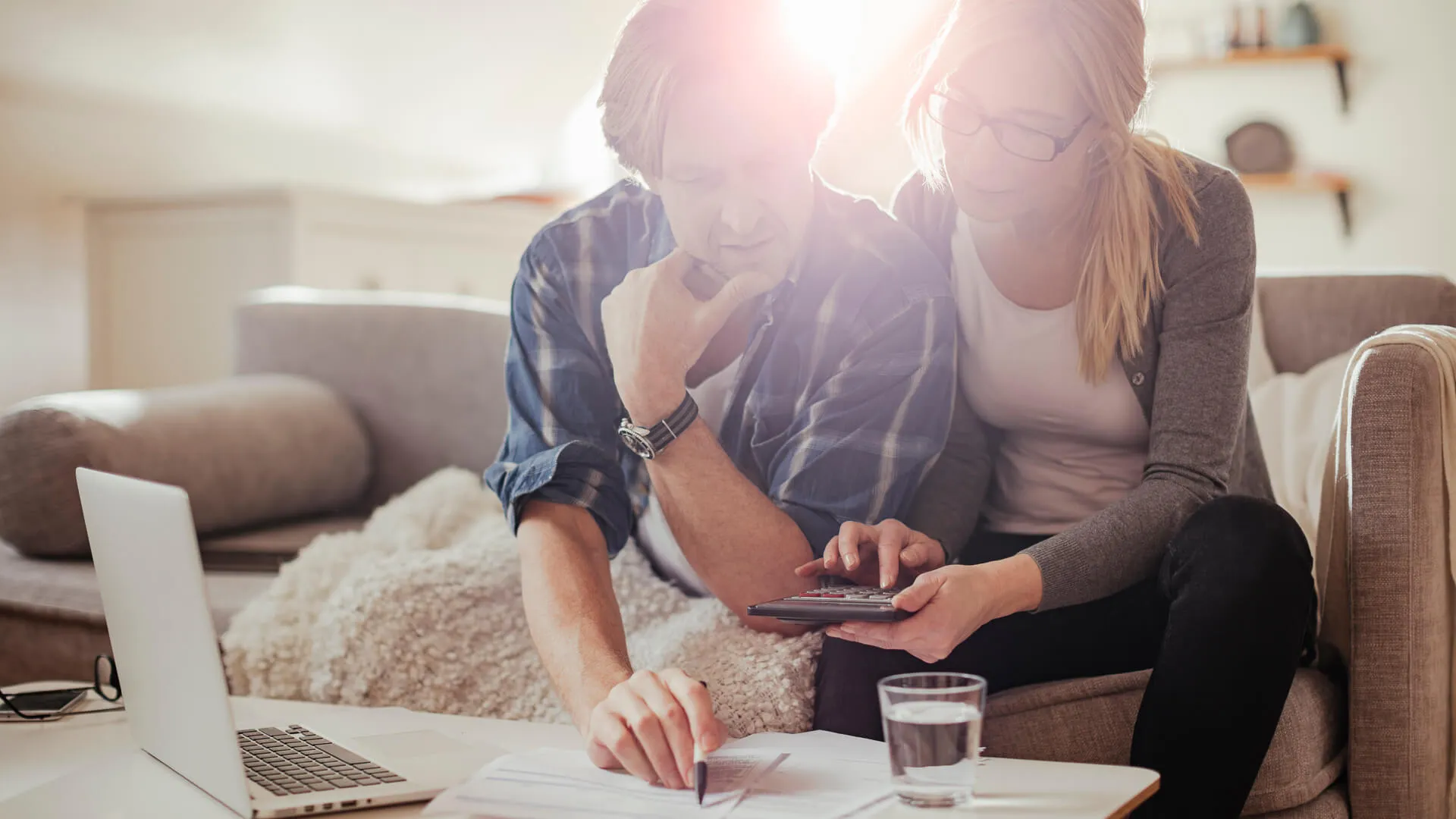 Photo of a worried mature couple calculating home finances.