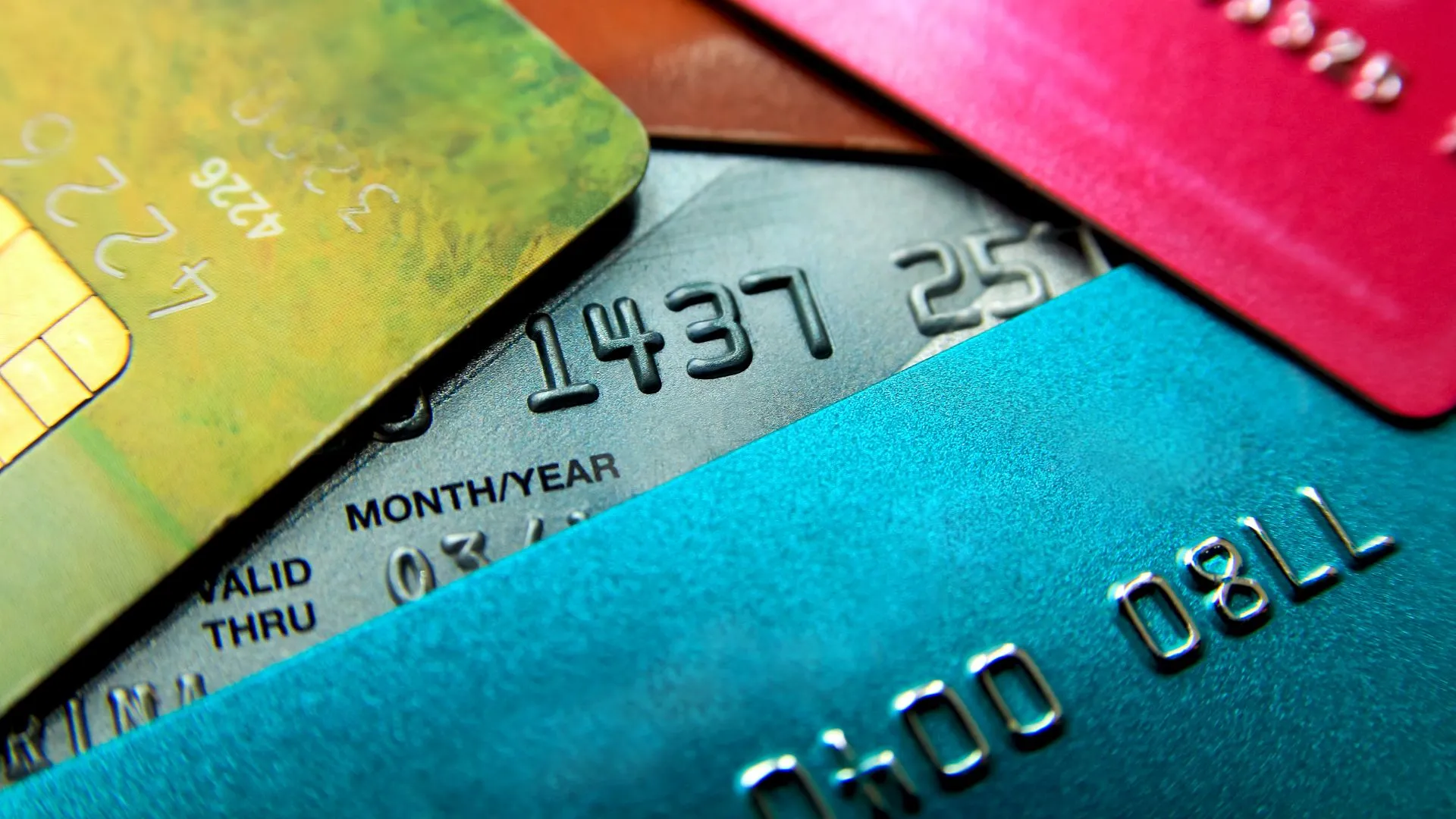 Stack of multicolored credit cards close-up view with selective focus.