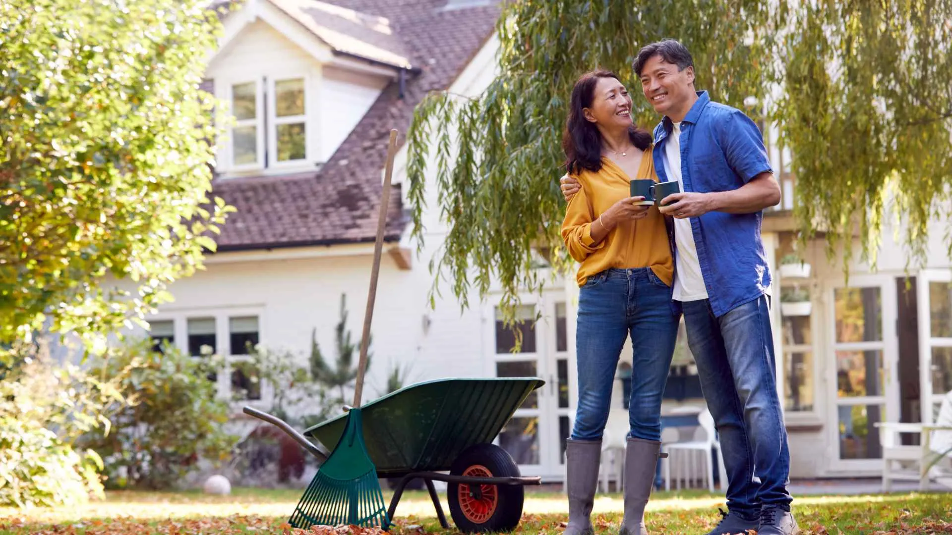 Couple smiling while standing outside their home.