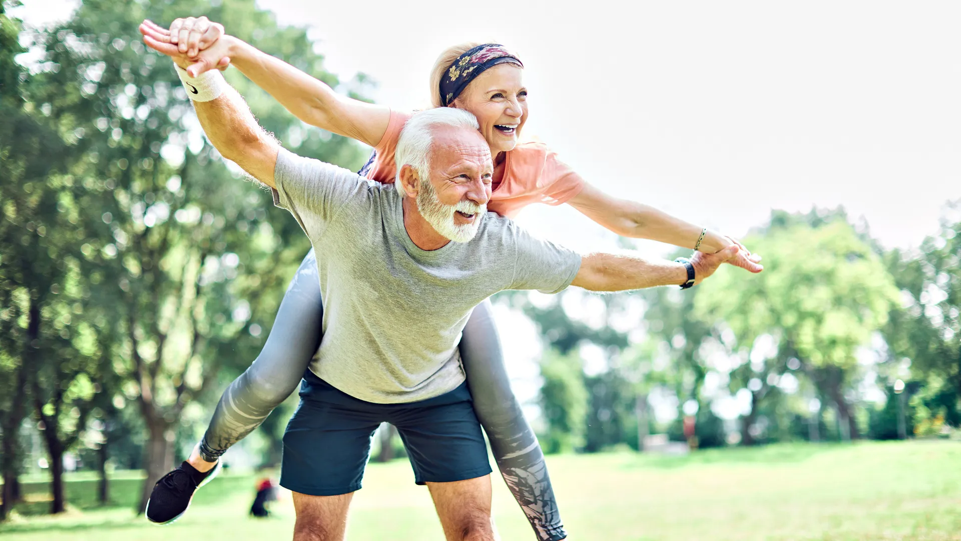 Smiling active senior couple having fun  together in the park.