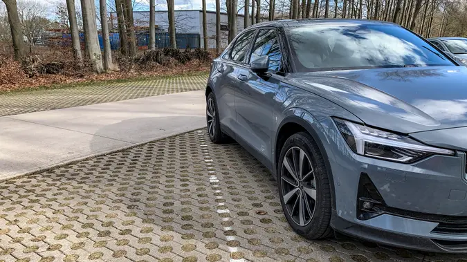 Polestar 2 all-electric 5-door fastback car in grey parked in a forest during a cold winter day with snow on the ground in Gelderland, The Netherlands.