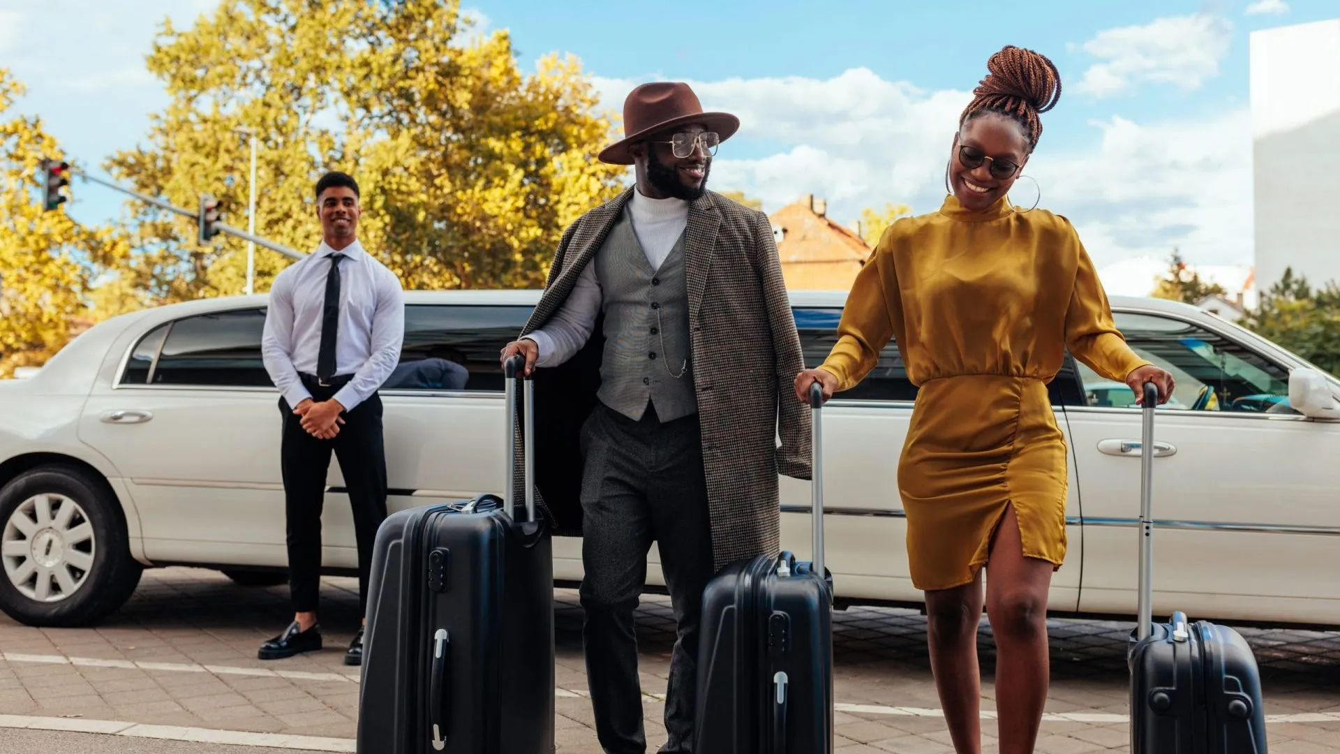 A wealthy African American couple is walking from the limousine to their hotel.