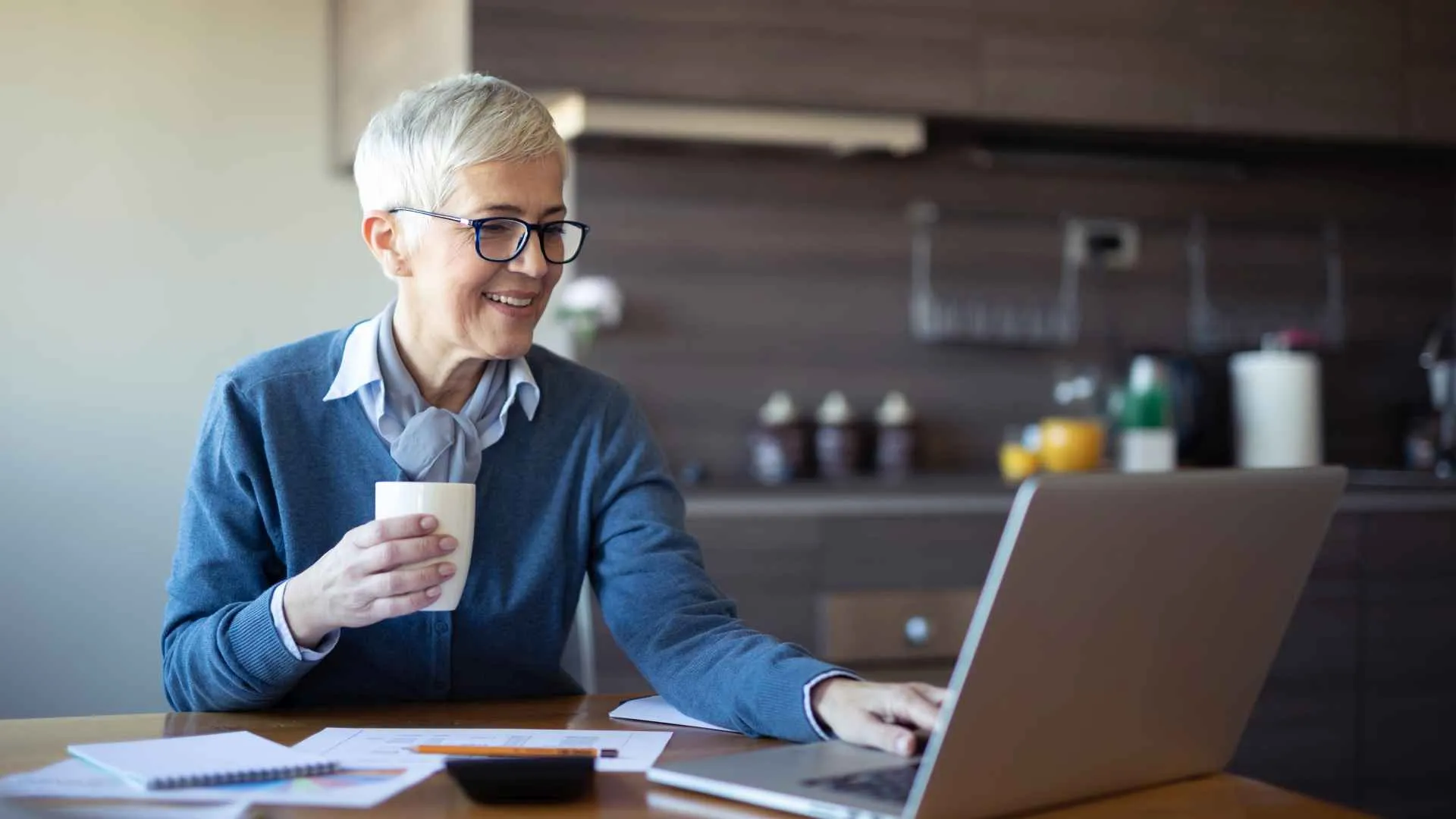 Female senior business woman using laptop at home office.