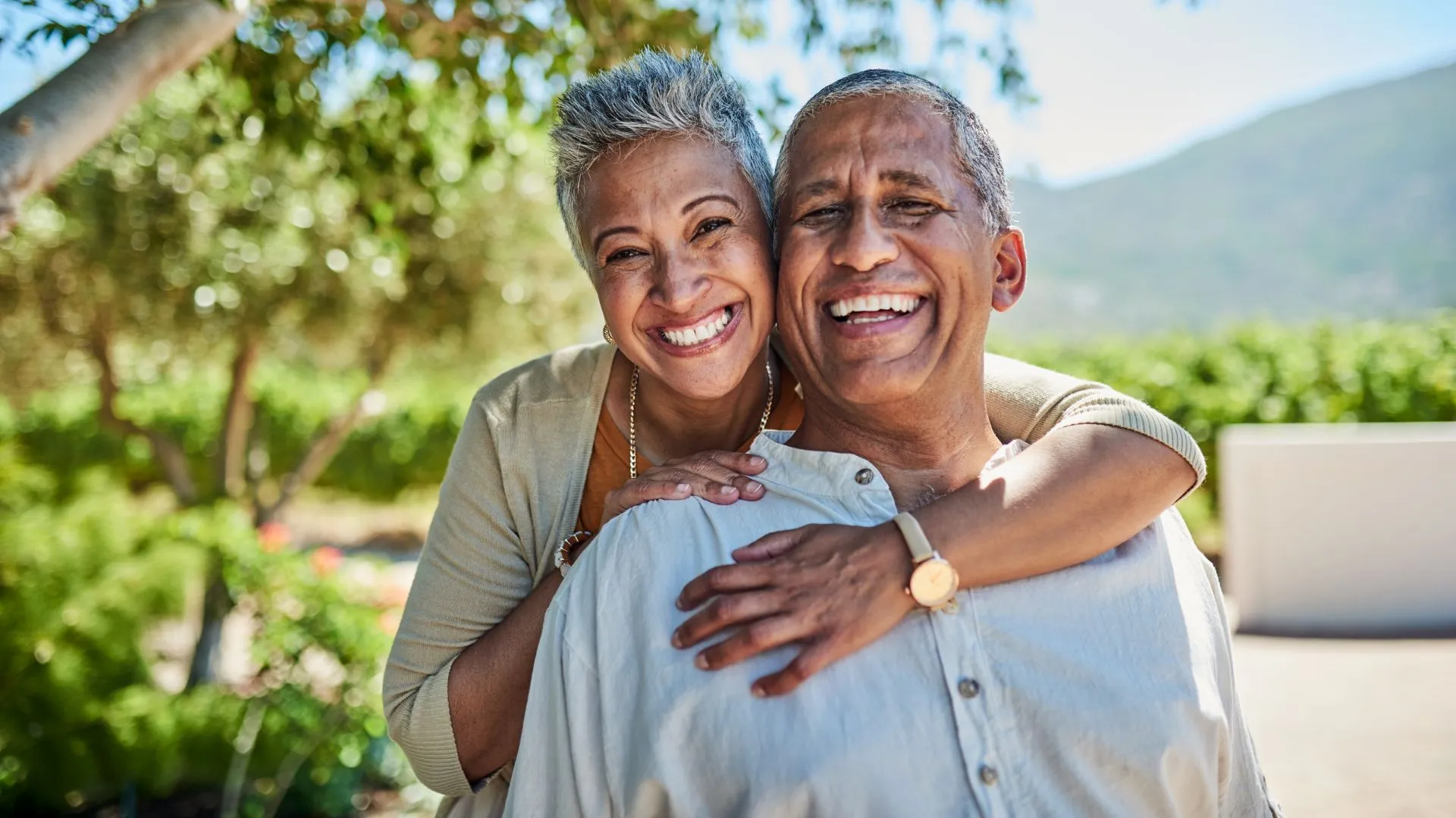 Senior couple, smile and outdoor in nature park showing love, care and happy on a retirement holiday on summer day.