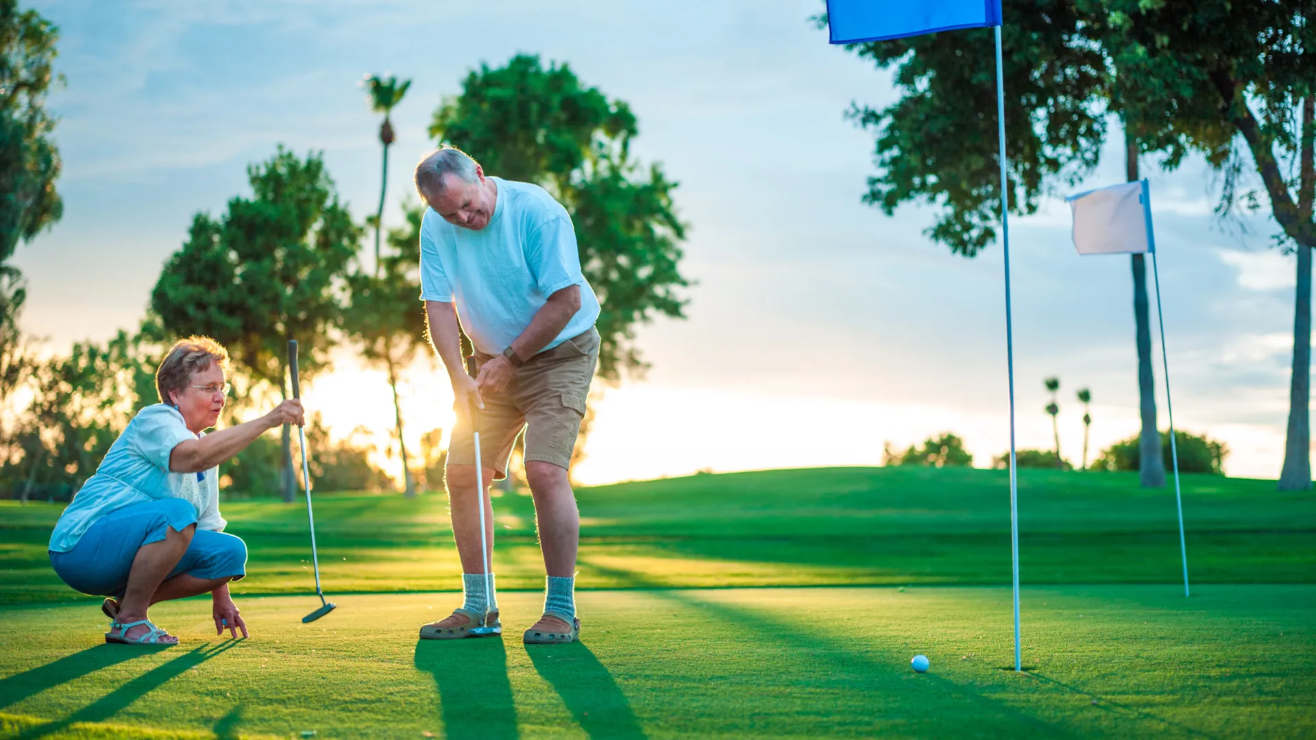 Active senior couple playing golf.